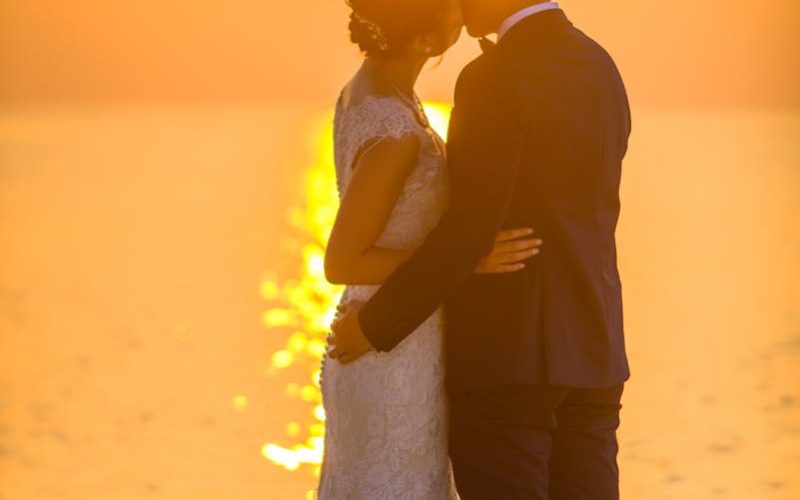 Man and Woman Kissing Under Sunset