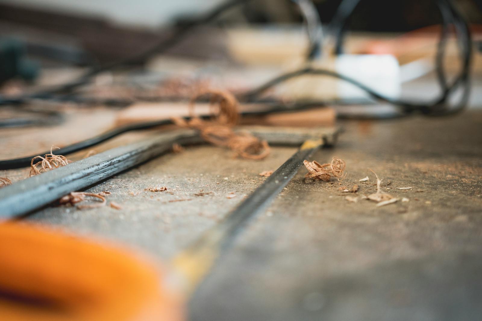 A messy workshop tabletop with tools and wood shavings, highlighting craftsmanship.