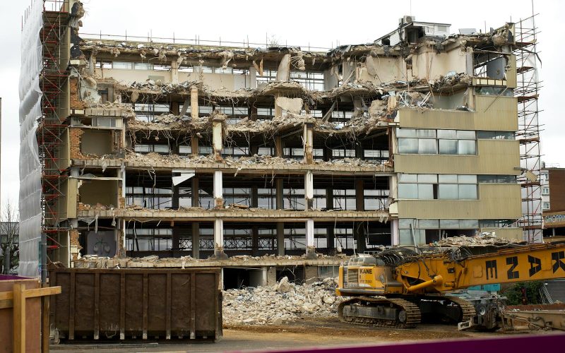 A large abandoned building undergoing demolition in England, showcasing damage and destruction.