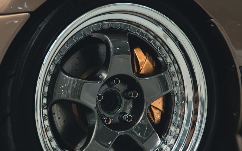 Detailed shot of a car's shiny chrome wheel rim, displaying its design and craftsmanship.