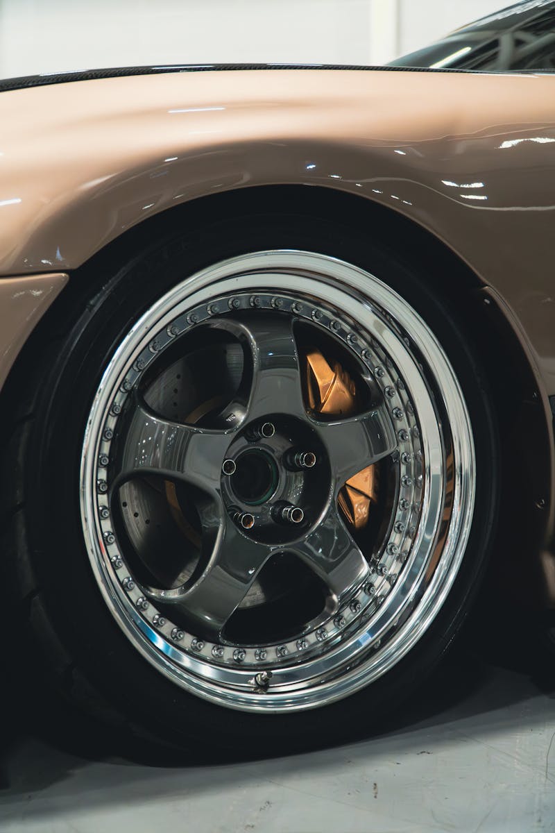 Detailed shot of a car's shiny chrome wheel rim, displaying its design and craftsmanship.