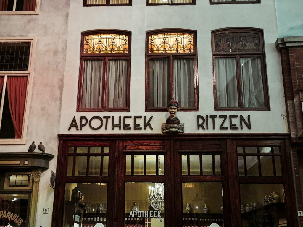 a store front with a statue of a man in the window