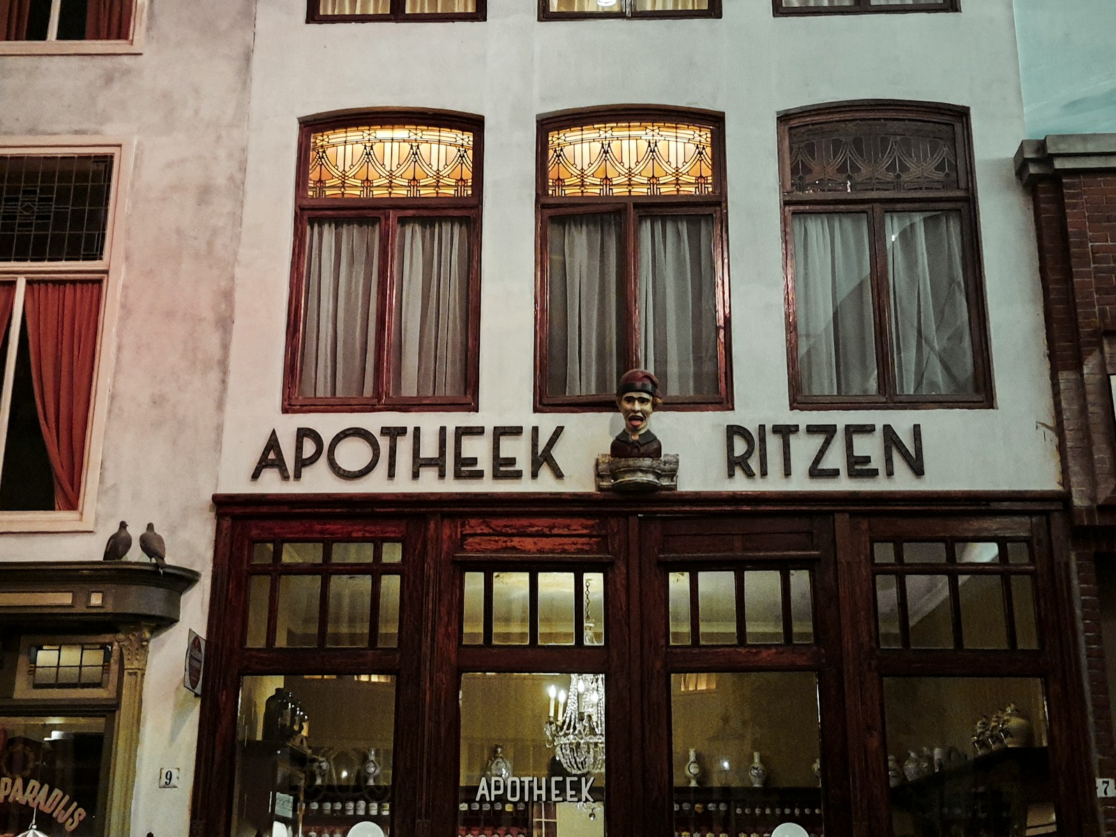 a store front with a statue of a man in the window