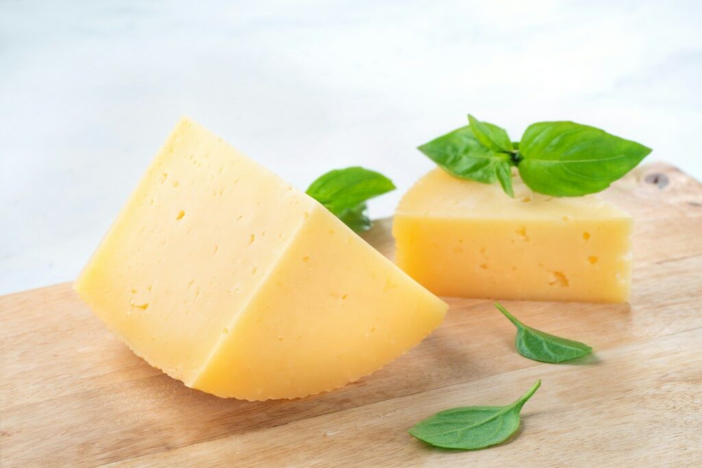 a piece of cheese with a leaf on top of it